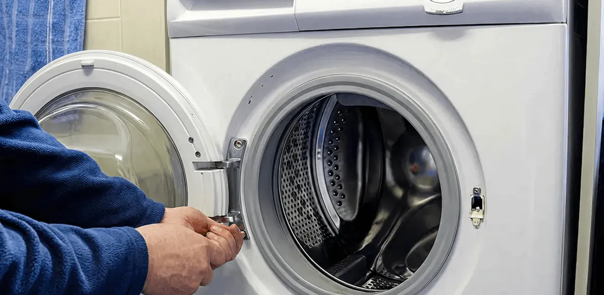Washing machine repair handyman checking a front-load washer door and latch in San Diego, CA