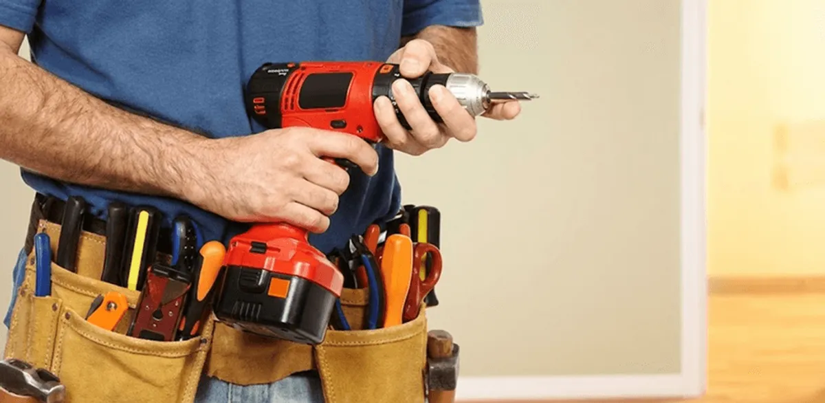 Handyman holding a power drill for home repairs and installations in San Diego, CA