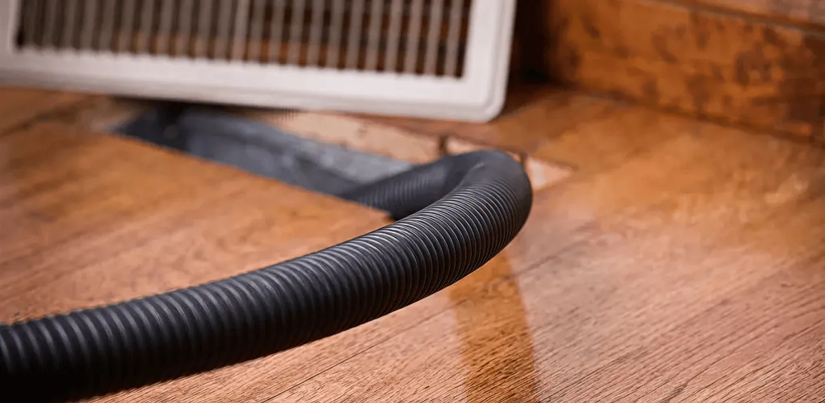 Air duct cleaning hose inserted into a floor vent for ductwork cleaning in San Diego, CA