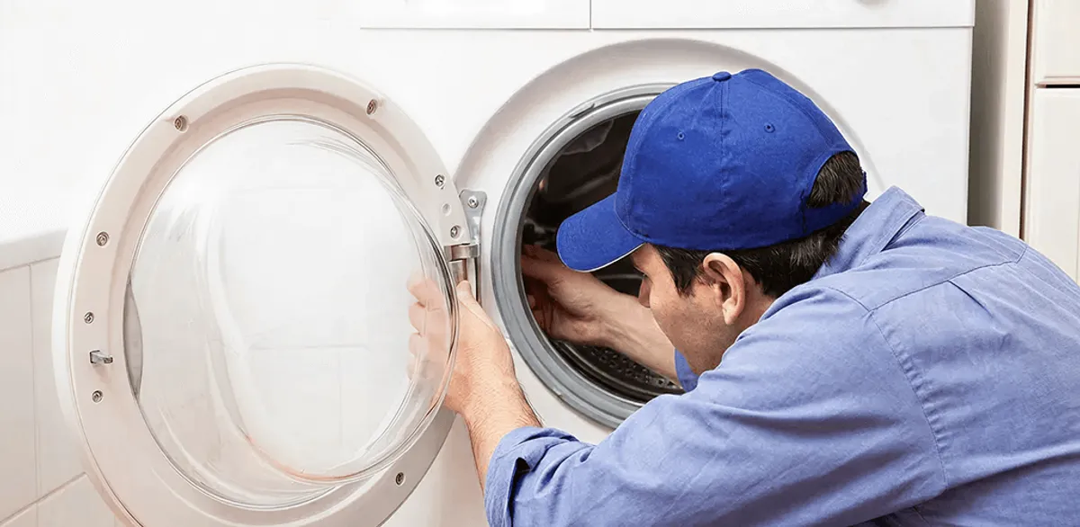 Washing machine repair handyman inspecting a front-load washer drum in San Diego, CA